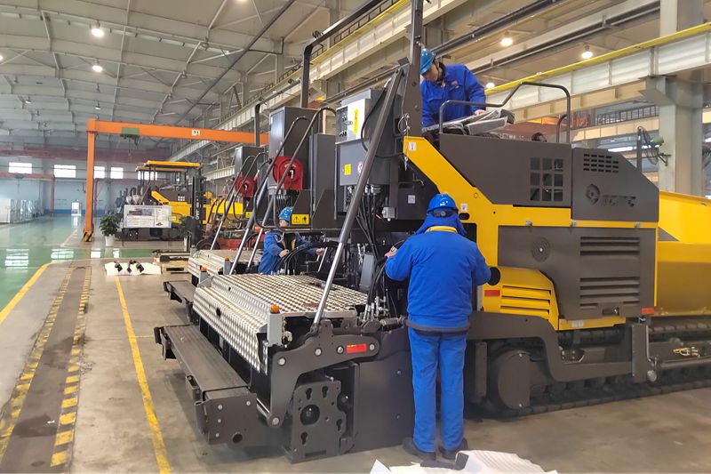 1、工人們抓緊時間總裝即將出口的瀝青混凝土攤鋪機.jpg